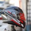 Axor Apex Turbine full-face helmet in matte black, grey, and red with a racing spoiler and clear visor.